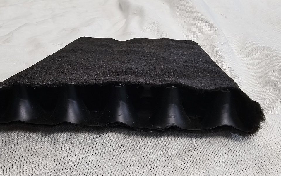 PercoStrip strip drain, showing the black filter fabric wrapped around the plastic drainage core